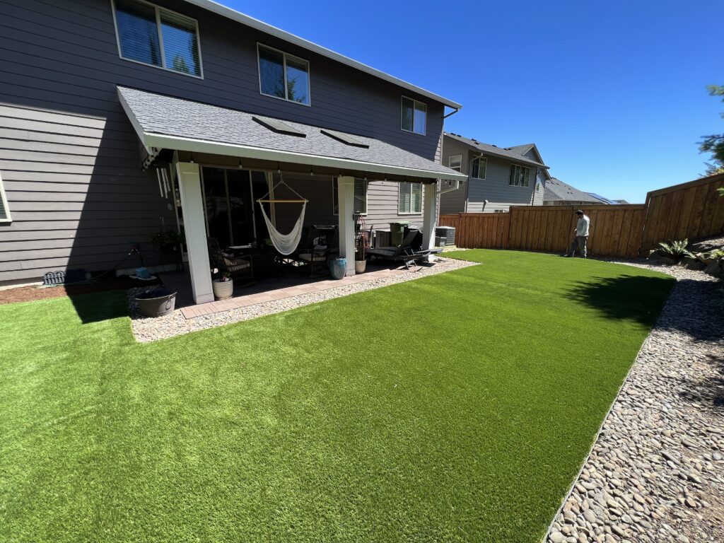 Artificial turf installed around a backyard patio